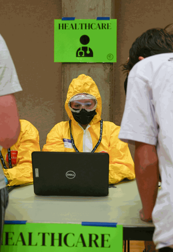 A student staffing the healthcare station in full protective gear